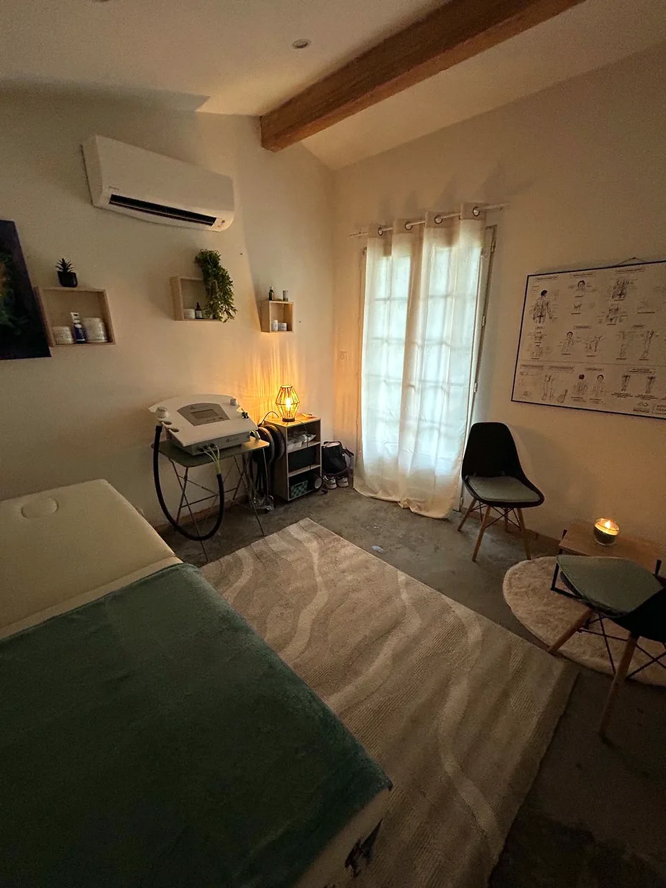 La salle de soins de Géraldine Gauthier, à Arles : la table recouverte d’un plaid vert, l’appareil de cryothérapie, une lampe allumée, deux chaises près de la fenêtre
