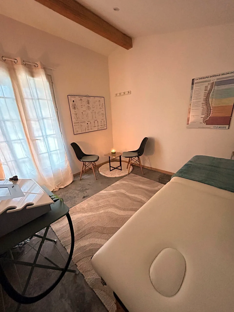 Sa salle de soins : deux chaises et une bougie près de la porte-fenêtre, deux planches du corps au mur
